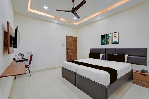 a bedroom with a bed and a ceiling fan at Super Townhouse Vanagaram Apollo Hospital Chennai Formerly V Hotels & Restaurant in Chennai