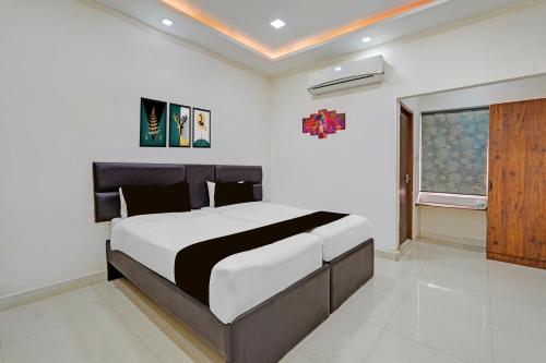 a bedroom with a large bed and a window at Super Townhouse Vanagaram Apollo Hospital Chennai Formerly V Hotels & Restaurant in Chennai