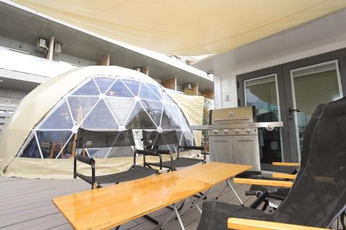 a tent on a deck with a table and chairs at Fukiagehama Field Hotel in Ichikikushikino