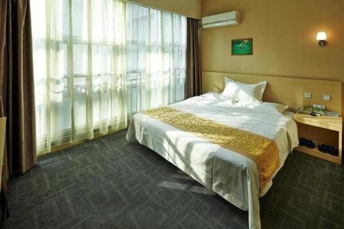 a hotel room with a bed and a large window at Super 8 Hotel Jinan Railway Station Square in Jinan