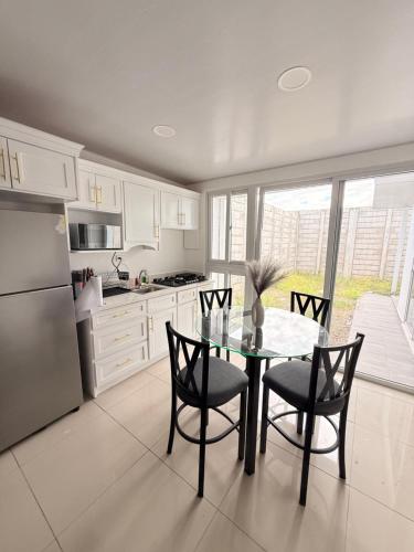a kitchen with a table and chairs and a refrigerator at Casa en San Miguel, el salvador in San Miguel