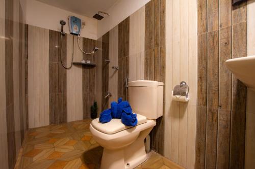 a bathroom with a toilet with a blue towel on it at Hotel Surf Resort in Arugam Bay
