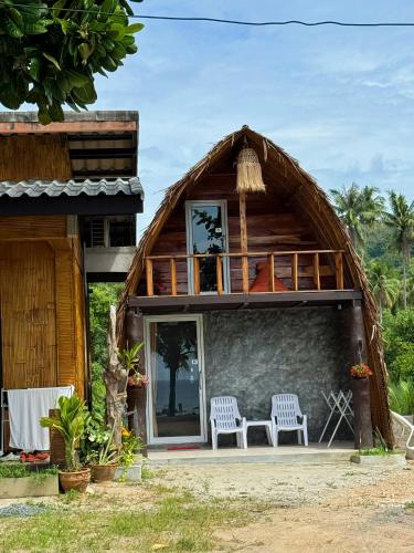 a house with two chairs in front of it at Lanta Wild Beach Resort in Ko Lanta