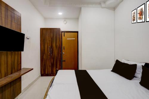 Un dormitorio con una cama y una puerta de madera. en Hotel O Oragadam Industrial Estates Chennai Formerly SSM Rooms, en Chennai