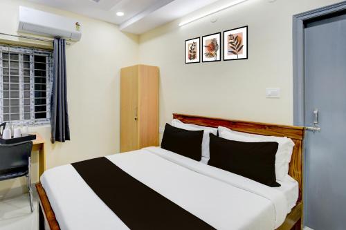 Un dormitorio con una cama con almohadas blancas y negras. en Townhouse Financial District Circle Hyderabad, en Gundipet