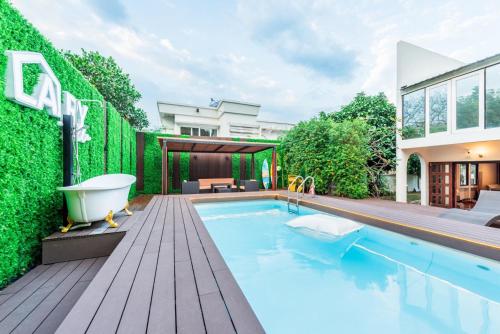 a bath tub sitting on a deck next to a swimming pool at Bangkok Cozy Garden Pool Villa Sukhumvit in Amphoe Phra Khanong