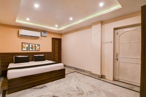 a bedroom with a bed and a sliding door at Super Collection O Puri Seaview Formerly Hotel Aavaas in Puri