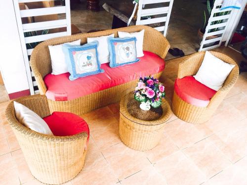 a living room with wicker chairs and a couch at NT House in Chiang Rai