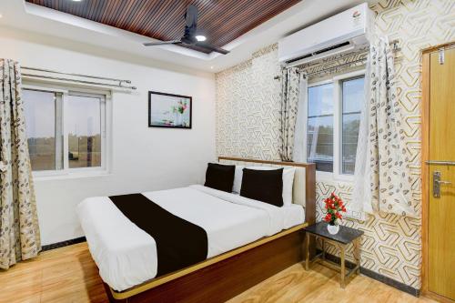 Un dormitorio con una cama y dos ventanas. en Collection O Kollur Prime Arena Formerly Hotel Krishna, en Kundakal