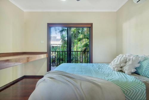 een slaapkamer met een bed en een balkon bij Kingfisher Vista in Cable Beach