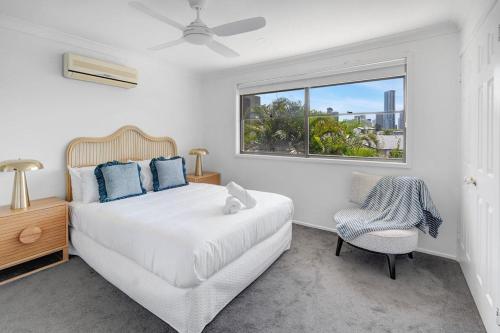 ゴールドコーストにあるPalm Springs Waterfront Retreat - Broadbeach Watersのベッドと窓のある白い寝室