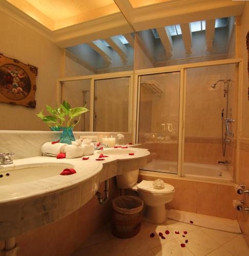 a bathroom with a sink and a toilet and a tub at Hotel Boutique La Mision De Fray Diego in Mérida