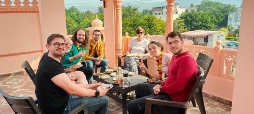 een groep mensen die rond een tafel op een balkon zitten bij The Vantage Haveli in Sawāi Mādhopur
