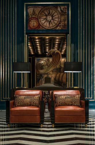 two chairs in a room with a clock and a mirror at Four Seasons Hotel Jakarta in Jakarta
