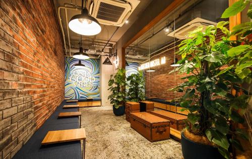 una fila de bancos en una habitación con plantas en The Kitchen Hostel Ao en Naha