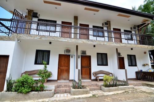 a house with wooden doors and a balcony at Highway to H Inn in Panglao Island