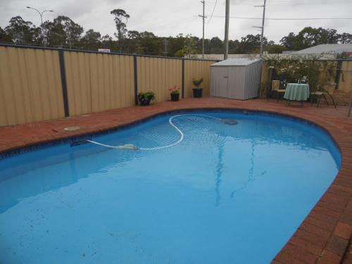 a large blue swimming pool in a backyard at Nanango Fitzroy Motel in Nanango