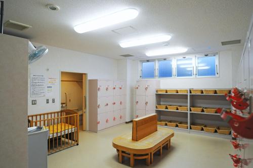 a waiting room with a crib and a bench and tables at Highland Furano in Furano