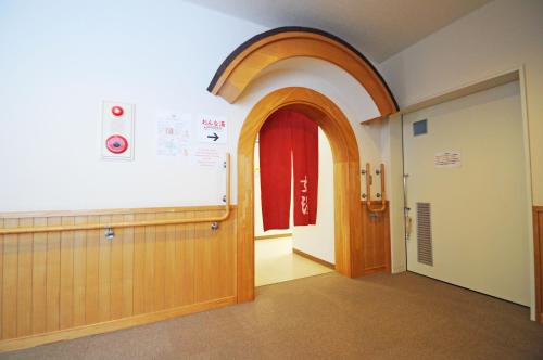 a hallway with an archway and a red door at Highland Furano in Furano