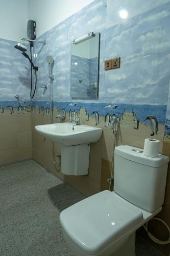 a bathroom with a sink and a toilet and a mirror at Sunset Reef Villa in Ratgama Hegoda