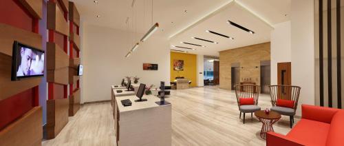 a living room with a red couch and a tv at ibis Kochi City Centre - An Accor Brand in Cochin
