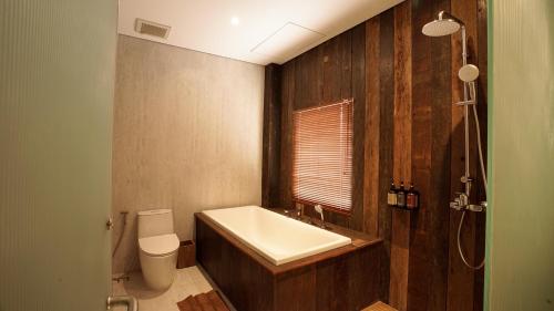 a bathroom with a white sink and a toilet at Uma Tilu By Seken Living in Yogyakarta