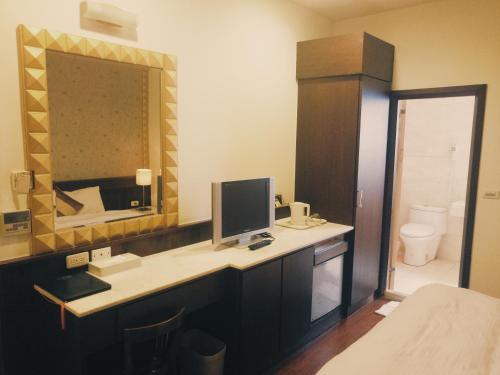 La salle de bains est pourvue d'un bureau avec un ordinateur et un miroir. dans l'établissement 玉泉旅館, à Jiaoxi