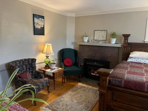 a bedroom with a bed and a fireplace and a chair at Plum Duff House in Tacoma