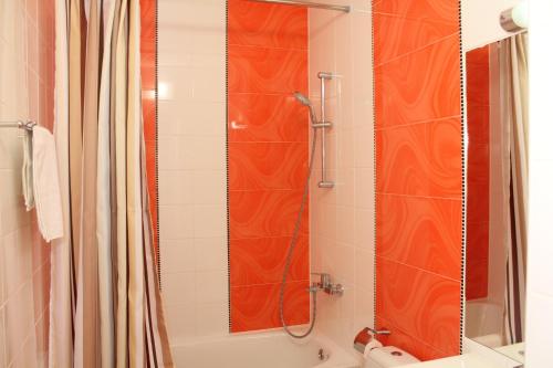 uma casa de banho com uma cortina de chuveiro laranja e uma banheira em Terasa em Stanishovka