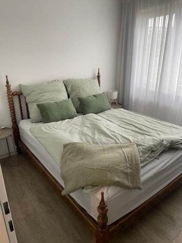 een slaapkamer met een groot bed met groene kussens bij Gustavs Rooftop in Oldenburg