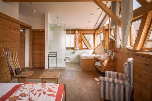 エールヴァルトにあるHotel Tirolerhof - Familotel Zugspitzeのベッドルーム1室(ベッド1台付)、バスルーム(窓付)