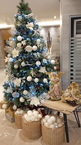ein Weihnachtsbaum mit Schmuck vor einem Weihnachtsbaum in der Unterkunft Sea Residences Moa Staycation- EVEREST in Sampong