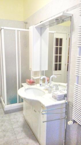 a white bathroom with a sink and a shower at Luna del Belvedere in Asti