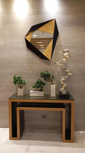 einem Tisch mit Topfpflanzen und einem Spiegel an der Wand in der Unterkunft Sea Residences Moa Staycation- EVEREST in Sampong