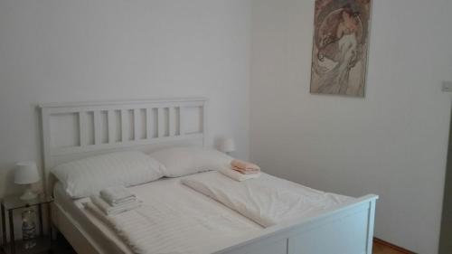 a white bed in a room with a picture on the wall at Ferienhaus Benetik am Sonneggersee in Sittersdorf