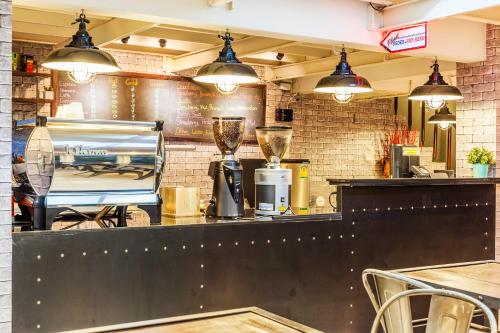 a restaurant with a bar with a counter and lights at At Hua Lamphong Hotel in Bangkok