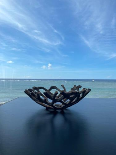 a metal bowl sitting on a table near the ocean at HERO VILLA ocean suite in Ishigaki Island