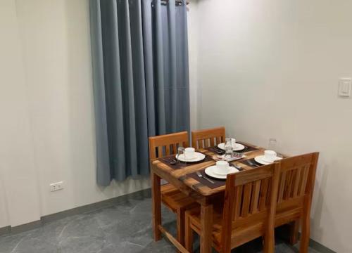 a wooden table with two chairs and a radiator at Piccadilly Green Villas Apartment in Dauis