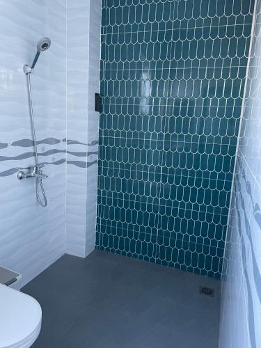 a bathroom with a blue tiled shower with a toilet at Habi Homestay Doc Let in Phú Thọ