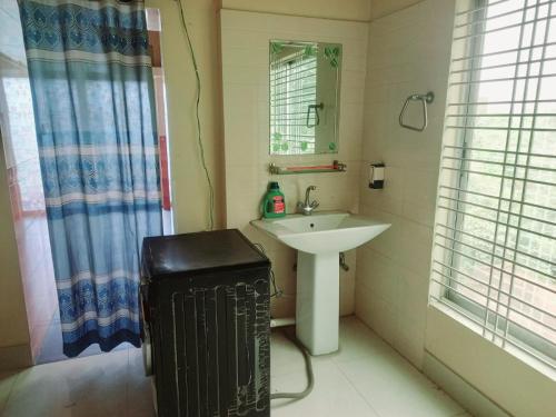 Un baño pequeño con lavabo y espejo. en Unique Village, en Boāli