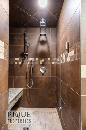 a bathroom with a shower with a shower head at Urban Oasis - with 16ft Swim Spa - Heated Hot Tub & Pool in Edmonton
