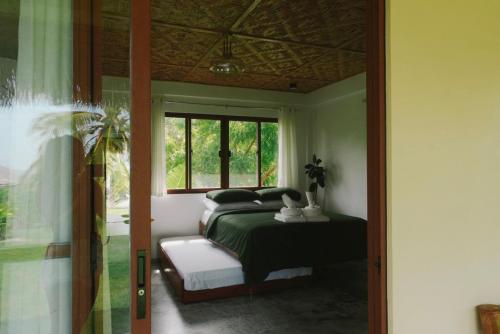 a bedroom with a bed and a window at Casa De Amor Lambug in Badian