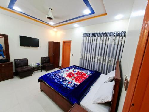 カラチにあるFamily Rose Guest House Millenniumのベッドとテレビのある寝室
