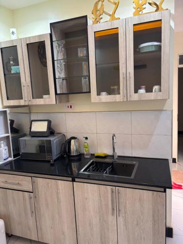 a kitchen with a sink and a microwave at Freetown resort-Gulu in Gulu