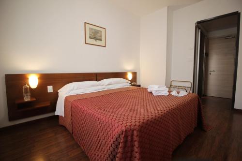 a bedroom with a large bed with a red blanket at Hotel Salieri in Legnago