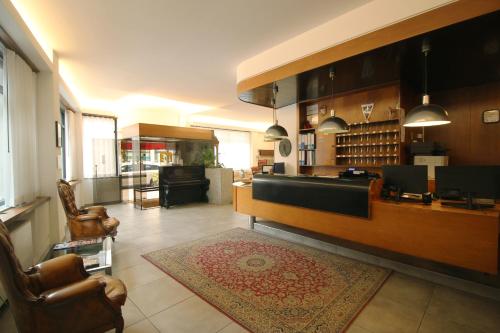 Una sala de estar con sillas y un bar con alfombra. en Hotel Salieri, en Legnago