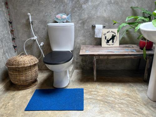 een badkamer met een toilet, een wastafel en een blauw tapijt bij Moksha eco villa Ella in Ella