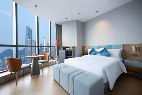 Un dormitorio con una cama grande y una ventana grande. en Pagoda Hotel Chongqing Jiefangbei, en Chongqing