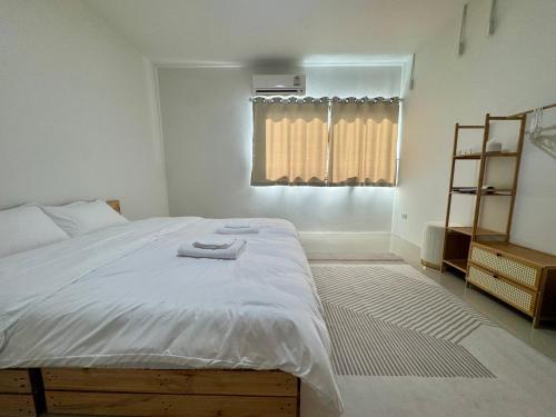 een slaapkamer met een groot bed en een raam bij Florent House in Chiang Mai