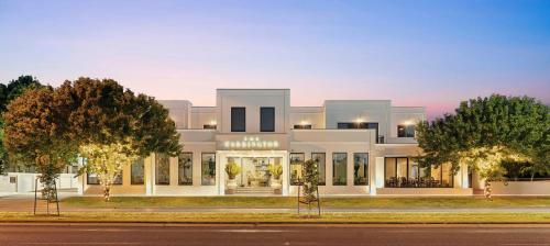 a large white building with trees in front of it at The Carrington Hotel in Shepparton